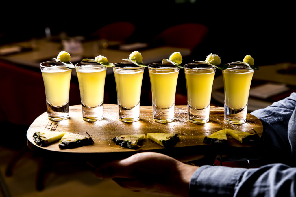 side view set alcoholic cocktails shot glasses with pineapple slices wooden board dark background scaled